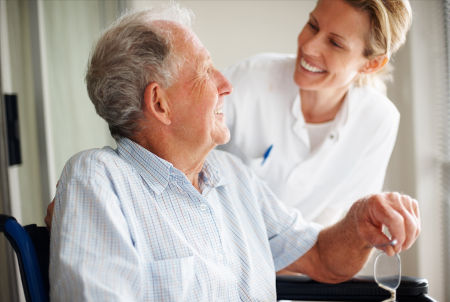senior-man-female-caregiver-smiling-450x302 caregiver with woman wheelchair
