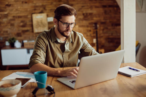 Male entrepreneur working on a computer at home. Male entrepreneur working on a computer at home.
